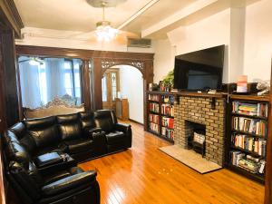 sala de estar con sofá de cuero y chimenea en KLO Guest House en Brooklyn