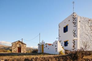 an old building in the middle of a field at Aspros Pyrgos in Volissos