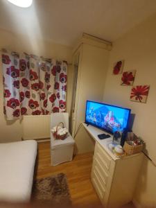 a room with a desk with a television and a bed at Double size and Single room in Barking in Barking