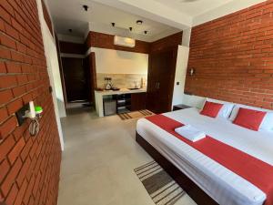 a bedroom with a large bed and a brick wall at Coastal Hideaway in Midigama