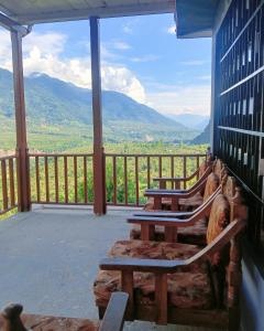a porch with benches and a view of the mountains at Wild Homestay in Baragrān