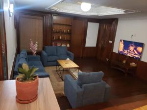 uma sala de estar com sofás azuis e uma televisão em Makach House- Traditional Boutique House with Garden em Kathmandu