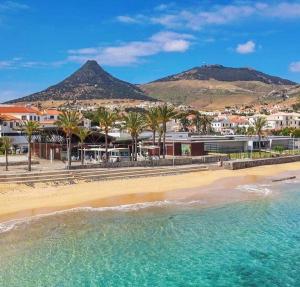 a view of a beach with palm trees and buildings at SandyBeachApartment in Porto Santo