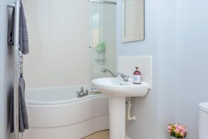 a white bathroom with a sink and a bath tub at The Pavilions by Select SA in Windsor