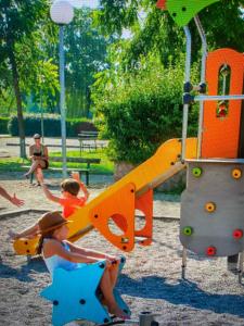 um grupo de crianças a brincar num parque infantil em MOBIL HOME Clim BOOFZHEIM 6 PERSONNES 3 CHAMBRES LE RIED 3 ETOILES PROCHE EUROPA PARK em Boofzheim