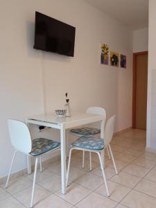 a white table and chairs with a television on a wall at Ivana in Fažana
