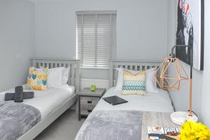 een slaapkamer met 2 bedden en een tafel bij The Pavilions by Select SA in Windsor