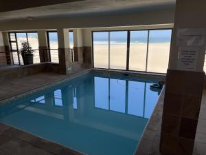 a swimming pool with a view of the beach at Paradise Beachfront Apartment in Jeffreys Bay