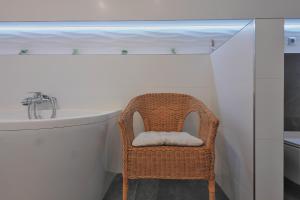 wiklinowe krzesło w łazience z umywalką w obiekcie Willa Barona Przy Termach Cieplickich w Jeleniej Górze