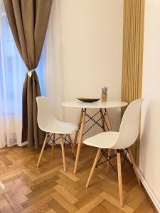 Una mesa y sillas en una habitación con ventana. en Schiller Studio, en Sibiu 6 fotos más
