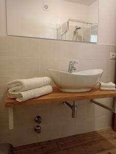 een badkamer met een wastafel, een spiegel en handdoeken bij Bed and Breakfast AnnA in Isera