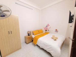 Dormitorio pequeño con cama con manta amarilla en Tiny Tigers Hostel, en Da Lat