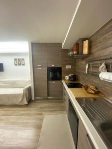 een keuken met een wastafel en een bed in een kamer bij Casetta San Pellegrino in Passo San Pellegrino