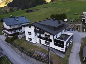 a large white house with a black roof at Alpenliebe Pitztal in Sankt Leonhard im Pitztal