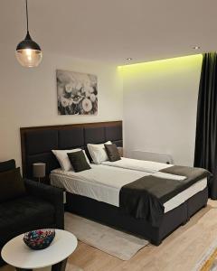 a bedroom with a large bed and a couch at Ice Dream Apartmani in Kopaonik