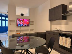 a kitchen and living room with a glass table and chairs at One in Se7en in St Julian's