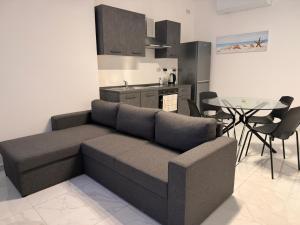 a living room with a couch and a table at One in Se7en in St. Julianʼs
