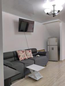 a living room with a black couch and a refrigerator at Apartamento Sarita 2 centro in Salento