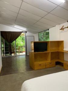 ein Schlafzimmer mit einem Bett und einem TV in einem Zimmer in der Unterkunft Hotel Michanti in El Zonte