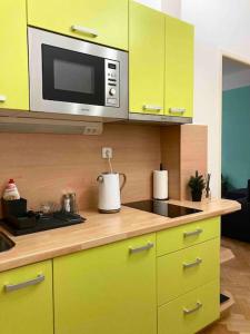 a kitchen with yellow cabinets and a microwave at Sunny flat in center of Prague in Prague