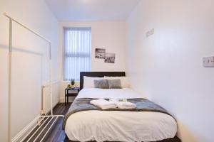 um quarto com uma cama grande com duas toalhas em Modern 6 Bed 3 Bath House em Colchester