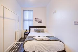 a bedroom with a large bed with two towels on it at Modern 6 Bed 3 Bath House in Colchester