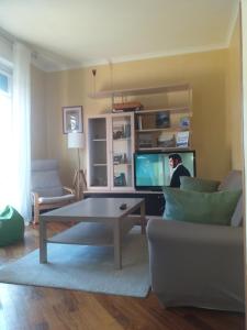 uma sala de estar com uma mesa de centro e uma televisão em Casa Patrone appartamento Luigi em Nebbiuno