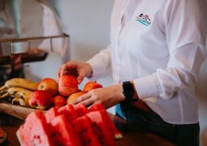 a chef holding a basket of fruit on a table at Hotel Chalé Capitólio in Capitólio