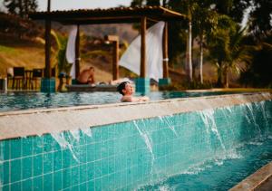 a young boy swimming in a swimming pool at Hotel Chalé Capitólio in Capitólio