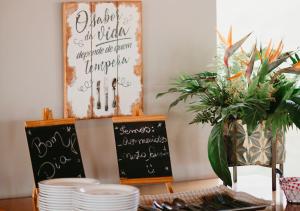 a table with plates and a sign on the wall at Hotel Chalé Capitólio in Capitólio