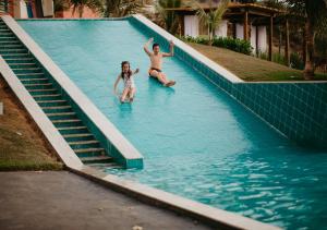 two people are in a swimming pool at Hotel Chalé Capitólio in Capitólio