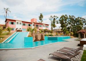 a swimming pool with lounge chairs in front of a building at Hotel Chalé Capitólio in Capitólio