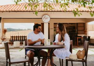 a man and a woman sitting at a table at Hotel Chalé Capitólio in Capitólio