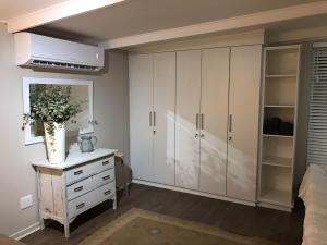 a bedroom with white cabinets and a dresser at Bloekomsrus in Senekal