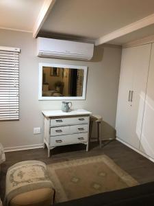 a living room with a dresser and a mirror at Bloekomsrus in Senekal