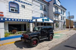 une jeep noire garée devant un bâtiment dans l'établissement Hotel Atenas, à Xalapa