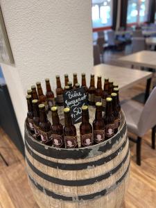 um monte de garrafas de cerveja sentadas num barril em Hotel The Originals Romans-sur-Isère Le Clos des Tanneurs em Romans-sur-Isère