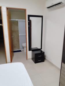 ein Bad mit einem Spiegel, einem Bett und einem WC in der Unterkunft CASA RODADERO SANTA MARTA in Santa Marta