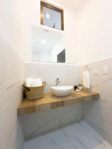 Baño blanco con lavabo y espejo en The Stay San Jose, en San José