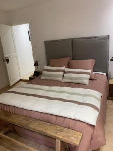 a bedroom with a large bed with pink and white pillows at le dit vin secret in Aigues-Mortes