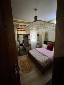 a bedroom with a large bed in a room at Home in Kira Namugongo. in Kira