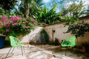 two chairs and a table in a yard with flowers at Hostal Casa Cucu - Wifi, Hot Water, AC, free water refill - Stay 3 nights or more and get 1 day free bikes & 1 free laundry wash in Valladolid