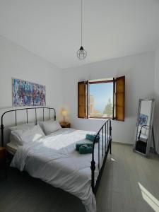 een slaapkamer met een bed, een spiegel en een raam bij Ritsos Family Apartment in Monemvasia
