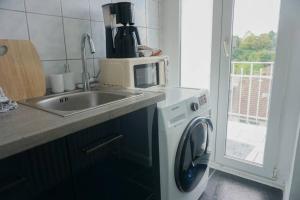 Il comprend une cuisine équipée d'un évier et d'un lave-linge. dans l'établissement Apartment with balkon, à Wuppertal