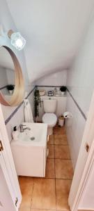 a white bathroom with a toilet and a sink at Our Place in the Sun in Huelva