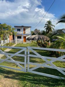 a white fence in front of a house at Cabaña La Blanquita in San Bernardo del Viento