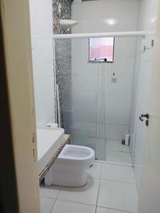 a white bathroom with a toilet and a shower at SOBRADO INGLESES in Florianópolis