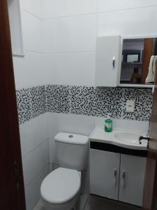 a white bathroom with a toilet and a sink at SOBRADO INGLESES in Florianópolis