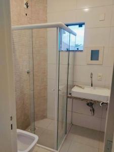 a bathroom with a glass shower and a sink at SOBRADO INGLESES in Florianópolis