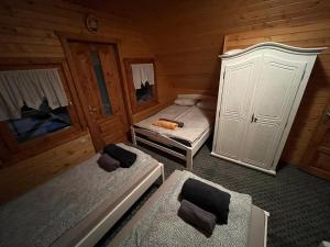 a small room with two beds and two chairs at Forest Guest House in Sîntimbru-Băi